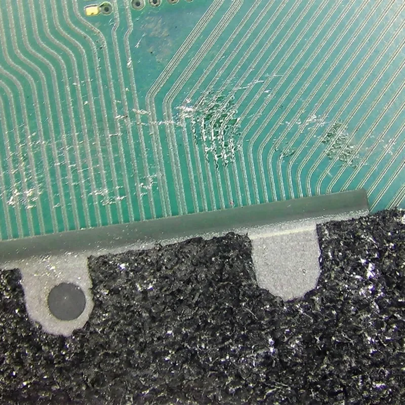 Liquid metal contamination on PS5 motherboard showing silvery spillage from DIY cleaning