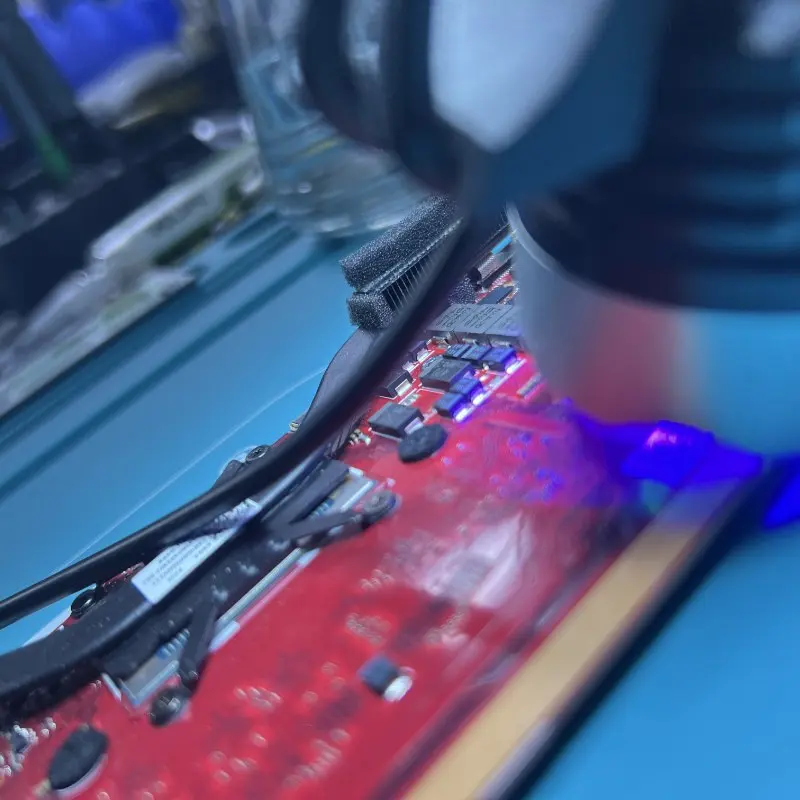 UV curing during microsoldering repair on an ASUS ROG Ally X motherboard at Seki Gadgets workshop